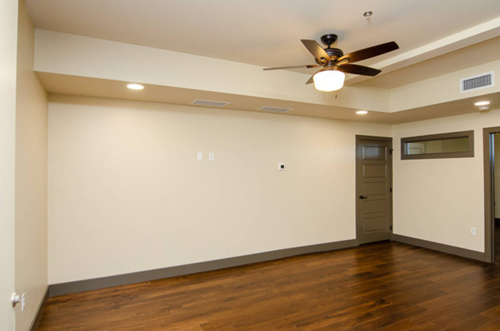 LOFT 3C LIVING ROOM WITH WOOD FLOORS, WHITE WALLS, AND CEILING FAN