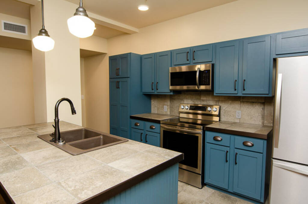 LOFT 3C KITCHEN WITH BLUE CABINETS AND STAINLESS STEEL APPLIANCES 